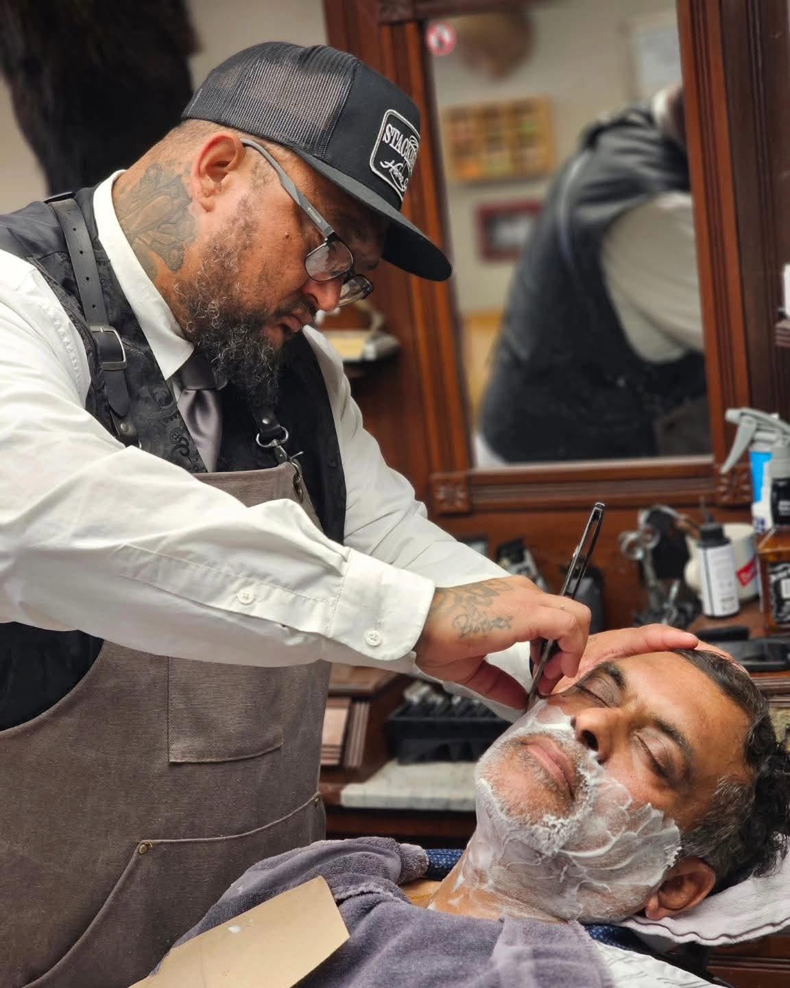 Barber giving a client a hot towel straight razor shave